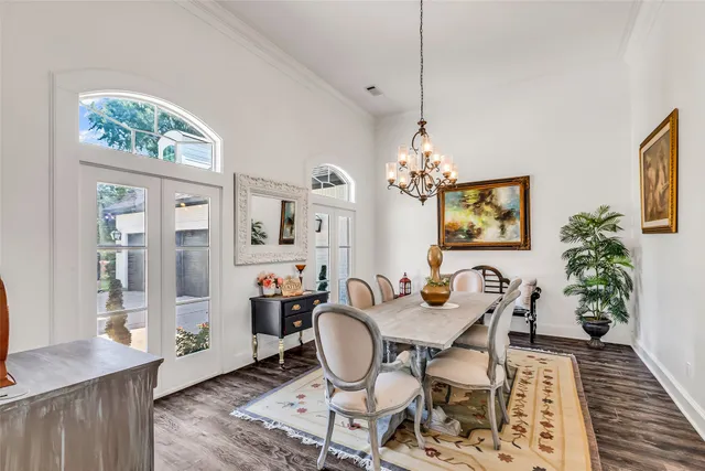 a dining room with furniture potted plants and wooden floor