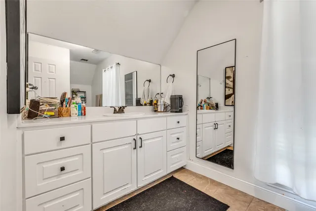 a spacious en suite bathroom with double sink and a mirror