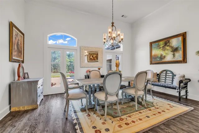a view of a dining room with furniture a rug and wooden floor