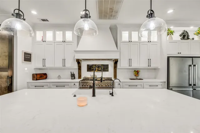a kitchen with stainless steel appliances a stove a sink and a refrigerator