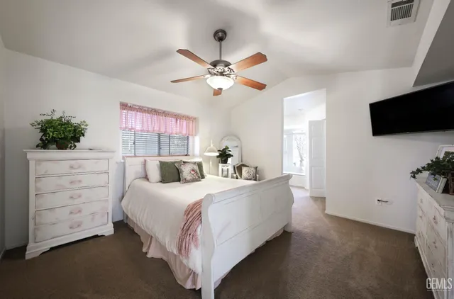 a bedroom with a bed a dresser and a flat screen tv