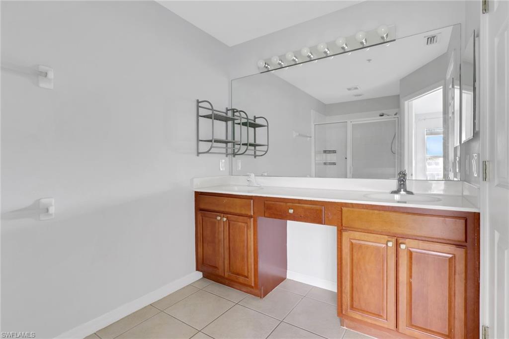 937 Hampton Circle, Unit 108 Naples, FL 34105 - Photo 13 of 32 a spacious bathroom with a granite countertop sink and a mirror