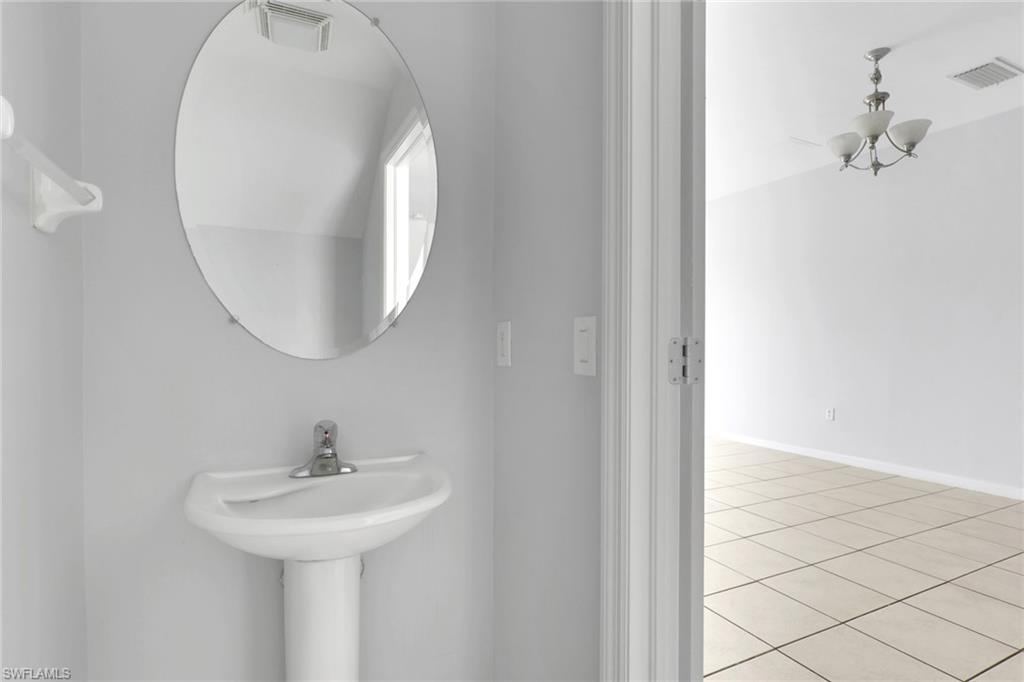 937 Hampton Circle, Unit 108 Naples, FL 34105 - Photo 14 of 32 a bathroom with a sink and mirror