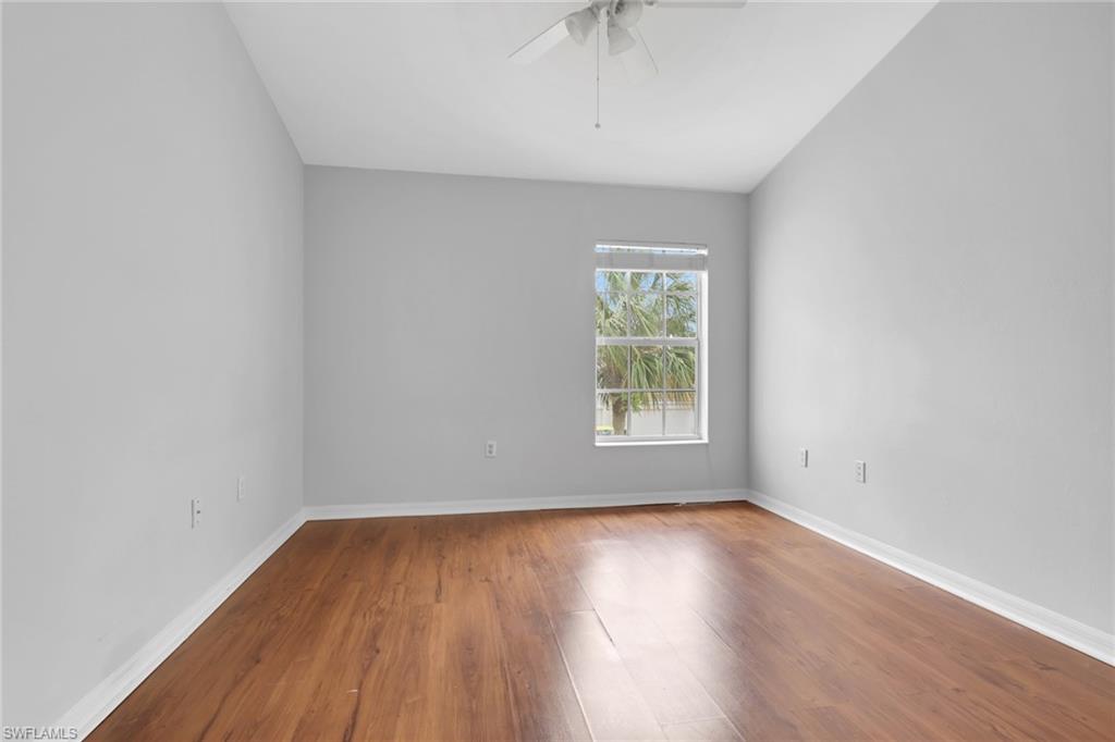 937 Hampton Circle, Unit 108 Naples, FL 34105 - Photo 19 of 32 an empty room with wooden floor and windows