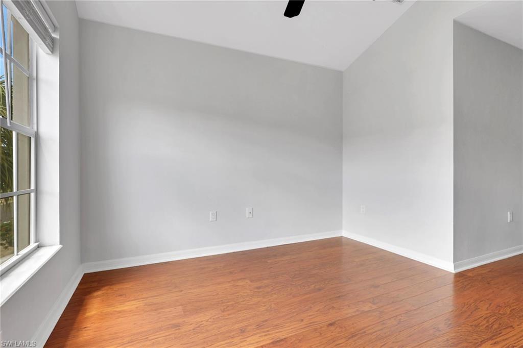 937 Hampton Circle, Unit 108 Naples, FL 34105 - Photo 20 of 32 a view of an empty room with wooden floor and a window