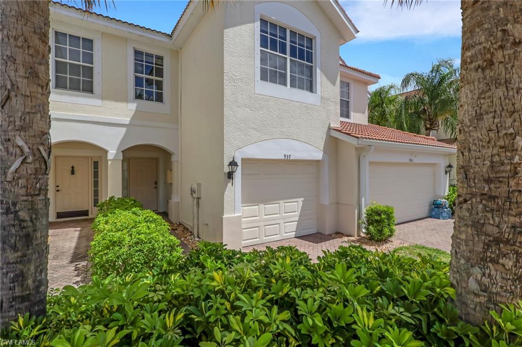 937 Hampton Circle, Unit 108 Naples, FL 34105 - Photo 2 of 32 front view of a house with a yard and potted plants