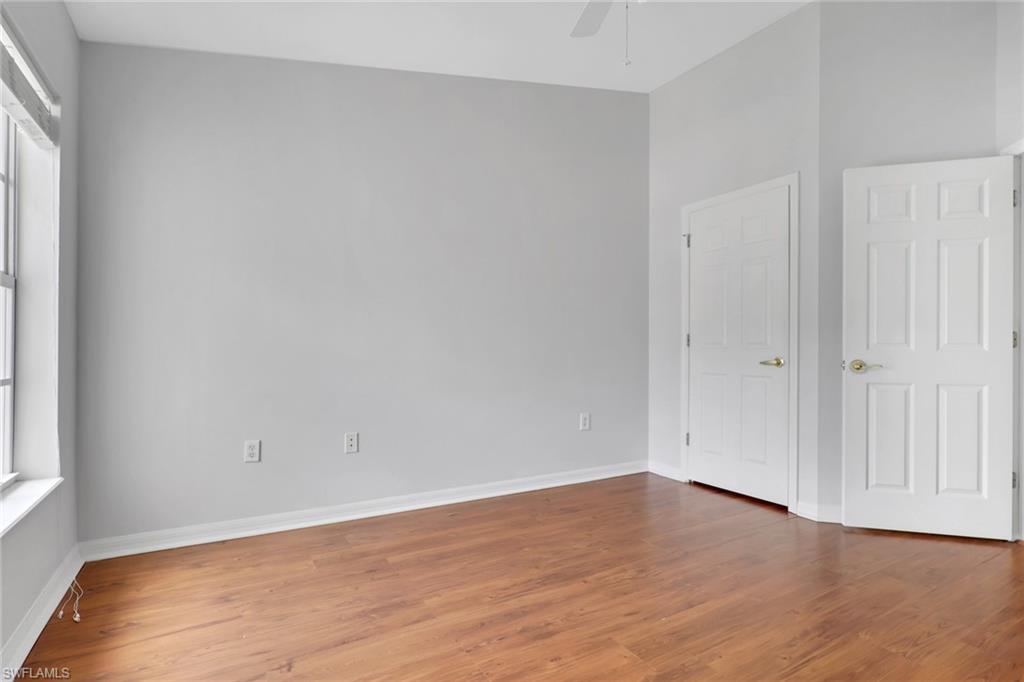 937 Hampton Circle, Unit 108 Naples, FL 34105 - Photo 23 of 32 a view of an empty room with wooden floor and a window