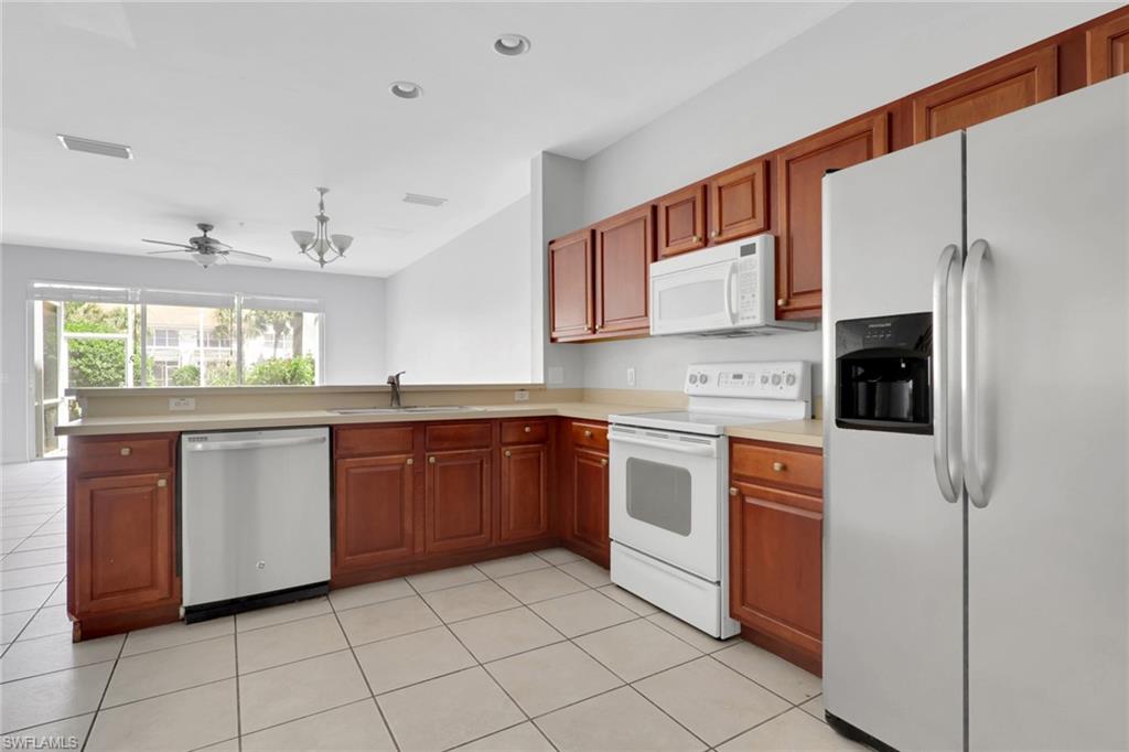 937 Hampton Circle, Unit 108 Naples, FL 34105 - Photo 5 of 32 a kitchen with stainless steel appliances granite countertop a refrigerator and a stove top oven