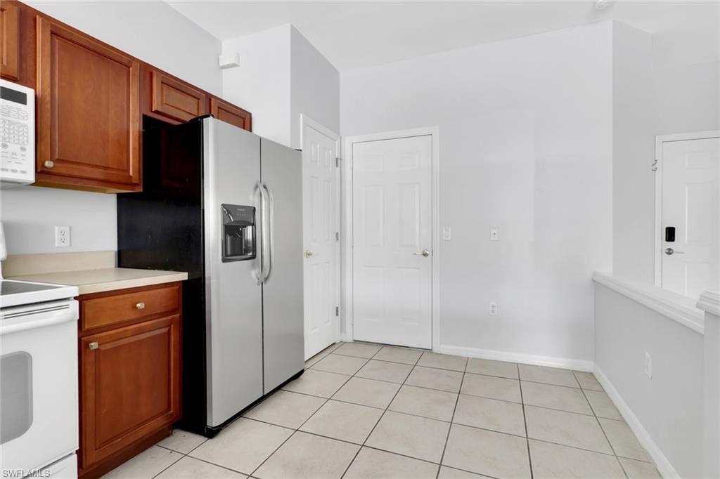 937 Hampton Circle, Unit 108 Naples, FL 34105 - Photo 7 of 32 a view of a kitchen with refrigerator and cabinets