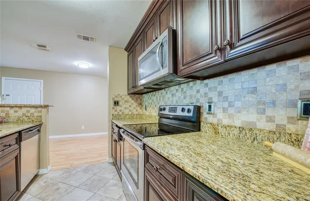 a kitchen with stainless steel appliances granite countertop a sink and a stove