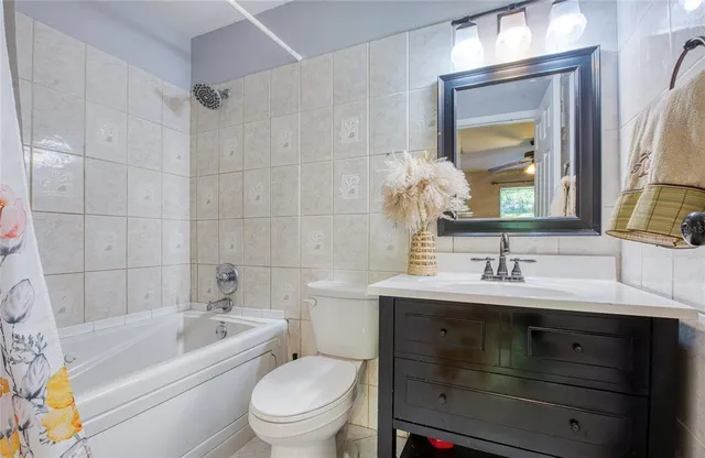 a bathroom with a toilet a sink a bathtub and a mirror