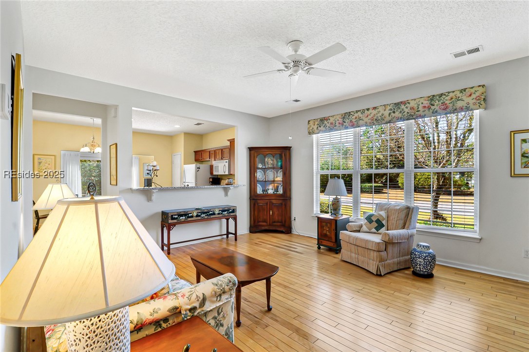 153 Landing Lane Bluffton, SC 29909 - Photo 5 of 31 Open living area with windows that let tons of natural light in! Hardwood floors complete the space.