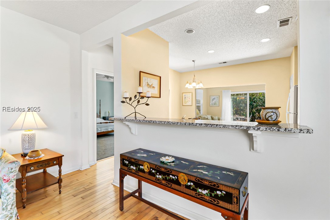 153 Landing Lane Bluffton, SC 29909 - Photo 7 of 31 Kitchen pass-through keeps everyone together & is great for entertaining or small gatherings. Primary bedroom is located off of the kitchen passage way. Granite counter could also be a great coffee or cocktail bar - just add a few barstools!