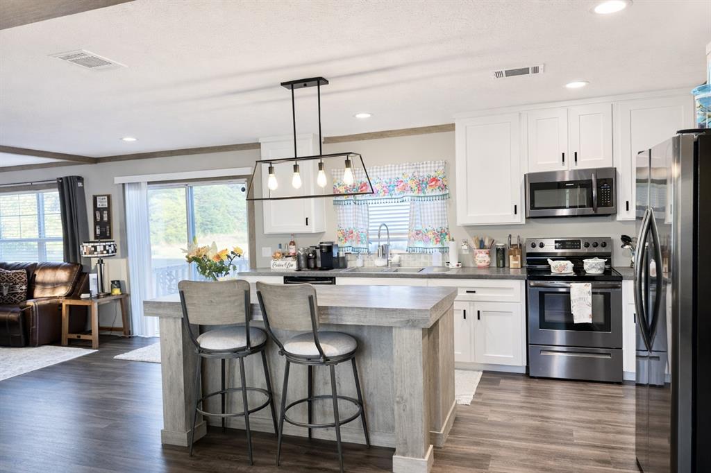 4504 Bethany Road Sherman, TX 75090 - Photo 5 of 20 a kitchen with stainless steel appliances a dining table chairs refrigerator and microwave