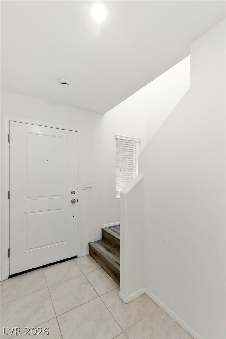 6227 Runestone Street Las Vegas, NV 89113 - Photo 16 of 33 Step into this welcoming entry featuring sleek tile flooring and a discreetly tucked away staircase.