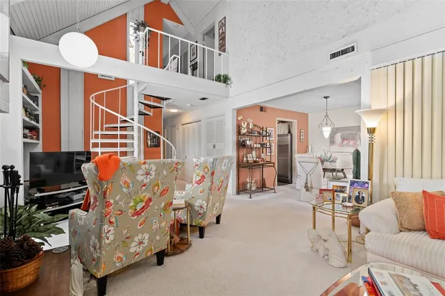 a living room with furniture a flat screen tv and a refrigerator