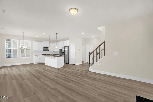 an empty room with windows and fireplace