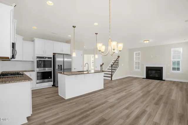 a view of empty room with wooden floor and fireplace