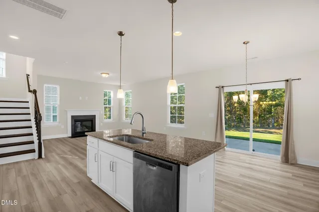 a kitchen with stainless steel appliances granite countertop a sink a stove and a refrigerator