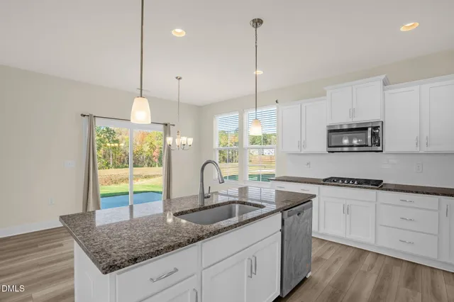 a kitchen with sink cabinets and wooden floor