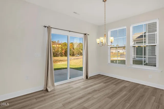 a kitchen with stainless steel appliances granite countertop a refrigerator a stove a sink and a wooden floor