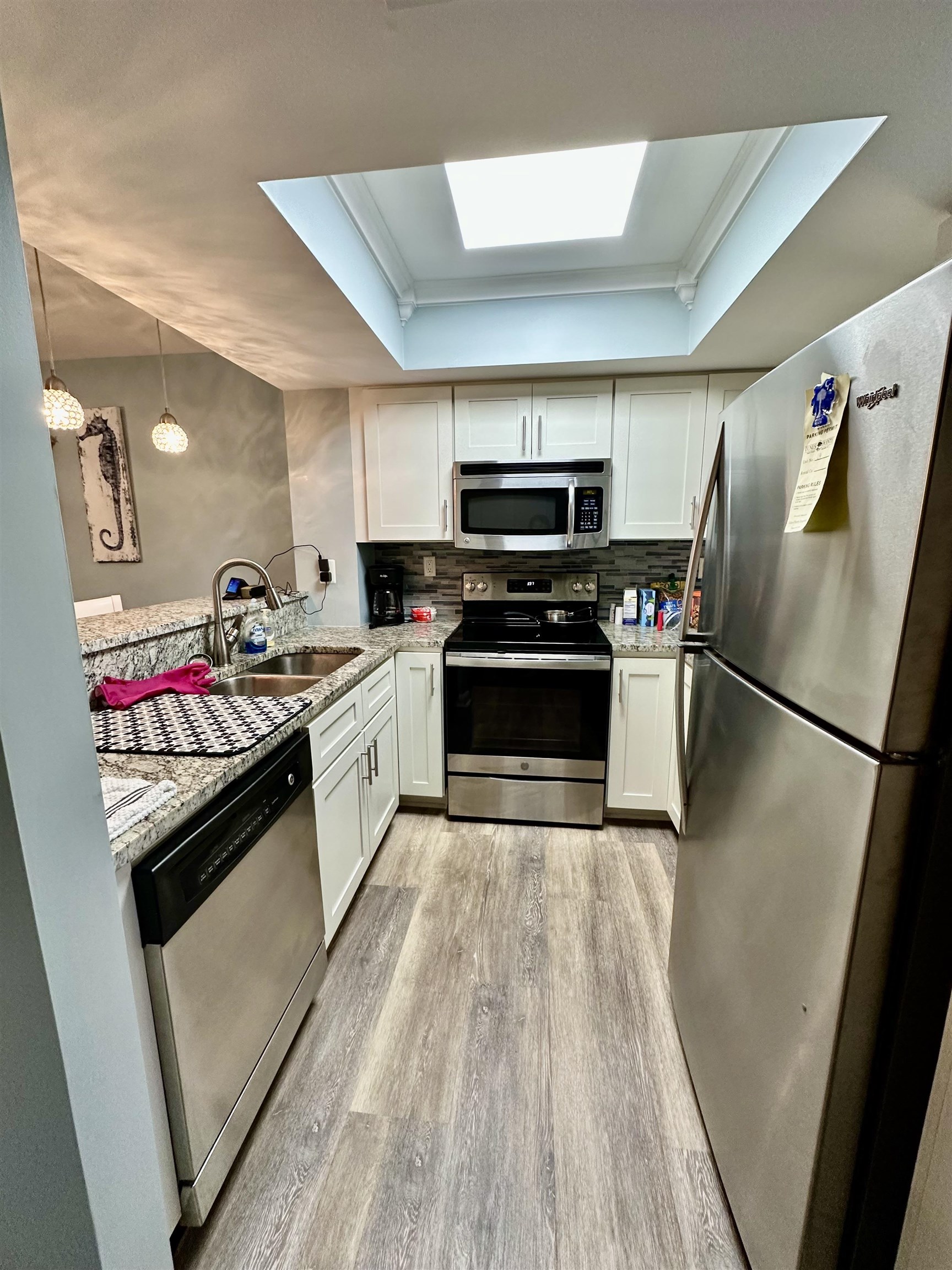 501 Maison Drive, Unit C9 Myrtle Beach, SC 29572 - Photo 8 of 27 Kitchen featuring appliances with stainless steel finishes, a raised ceiling, tasteful backsplash, white cabinets, and light stone countertops