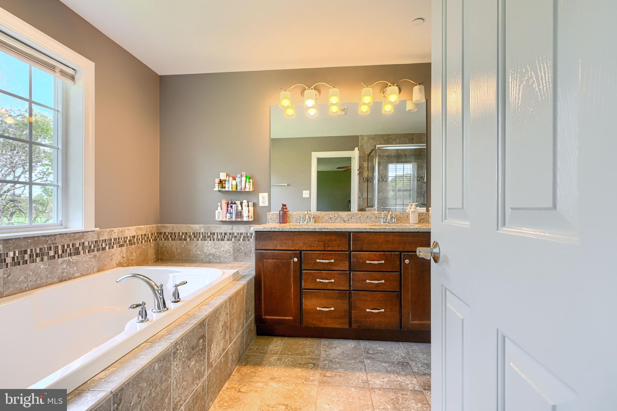 13012 Liberty Road Union Bridge, MD 21791 - Photo 26 of 47 a bathroom with a tub a double vanity sink and a large mirror
