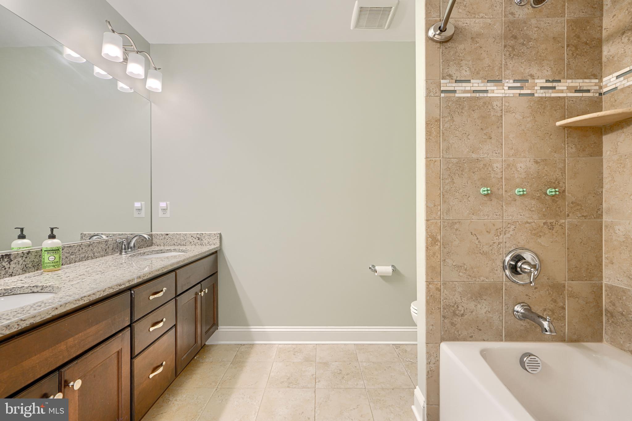 13012 Liberty Road Union Bridge, MD 21791 - Photo 34 of 47 a bathroom with a granite countertop sink a mirror and a bathtub