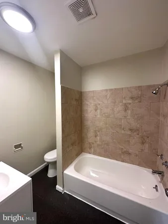 a bathroom with a bathtub and a toilet