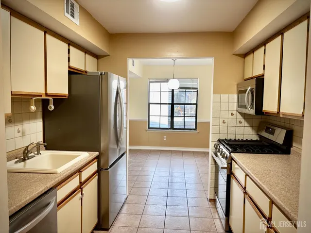 a kitchen with stainless steel appliances a sink stove and refrigerator