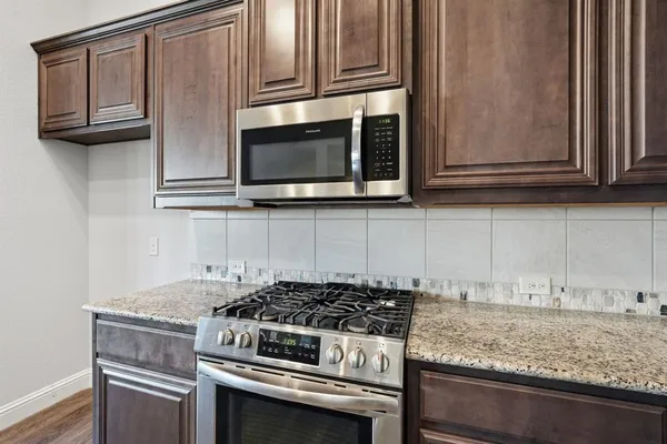 a kitchen with granite countertop cabinets stainless steel appliances and wooden cabinets