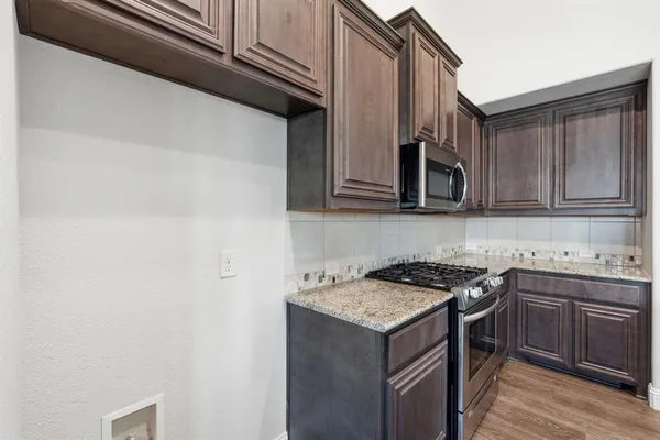 a kitchen with stainless steel appliances granite countertop a sink stove and microwave