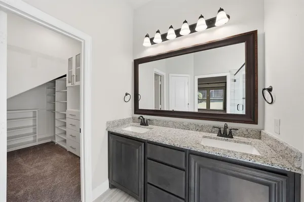 a bathroom with a granite countertop sink and a mirror