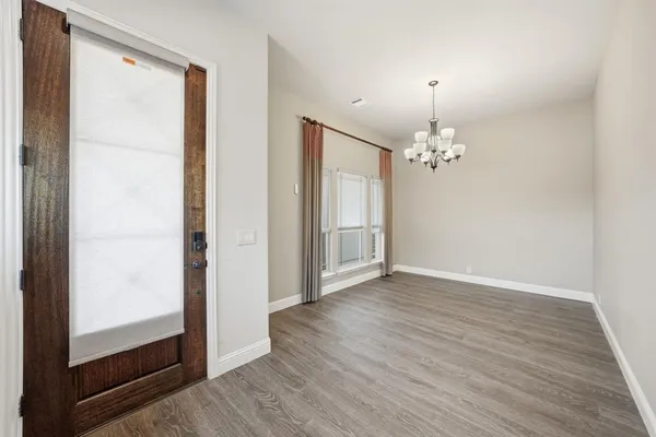 a view of a chandelier in big room and wooden floor