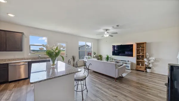 a living room with furniture flat screen tv and wooden floor
