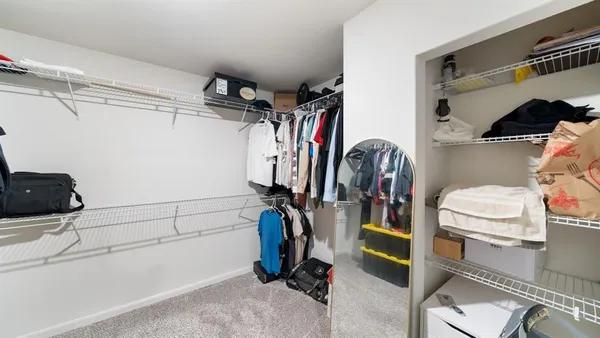 a view of walk in closet with clothes and shoes