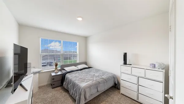 a bedroom with a bed and a flat screen tv