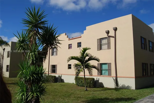 a front view of multiple houses with yard