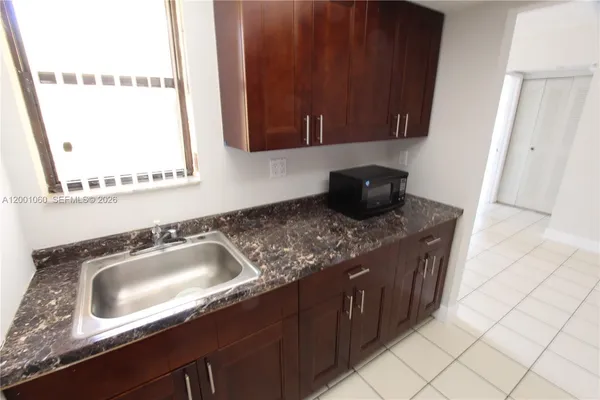 a kitchen with granite countertop a sink and a stove