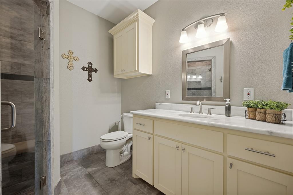 8400 Holder Road Northlake, TX 76247 - Photo 19 of 36 Walk-in shower with tile surround, vanity with light-colored cabinetry, polished countertop, and an integrated sink