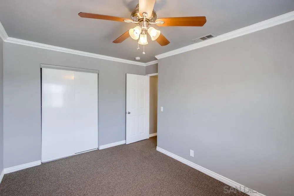 880 Friendly Circle El Cajon, CA 92021 - Photo 19 of 27 an empty room with a chandelier fan and a chandelier fan
