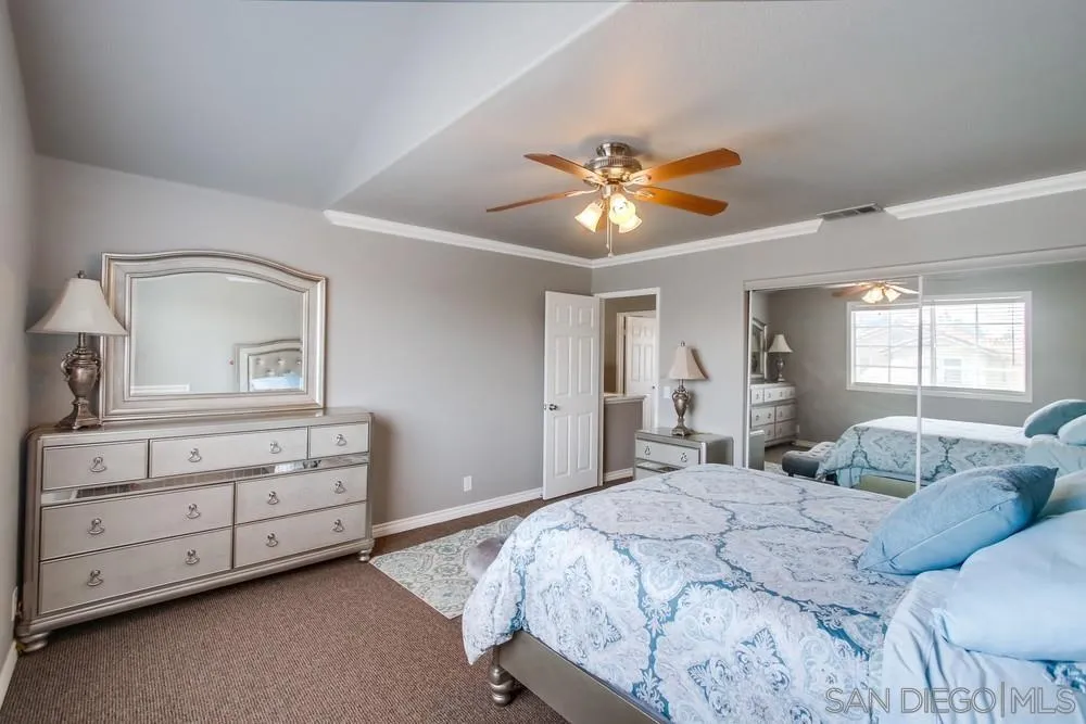 880 Friendly Circle El Cajon, CA 92021 - Photo 24 of 27 a bedroom with a large bed and a chandelier