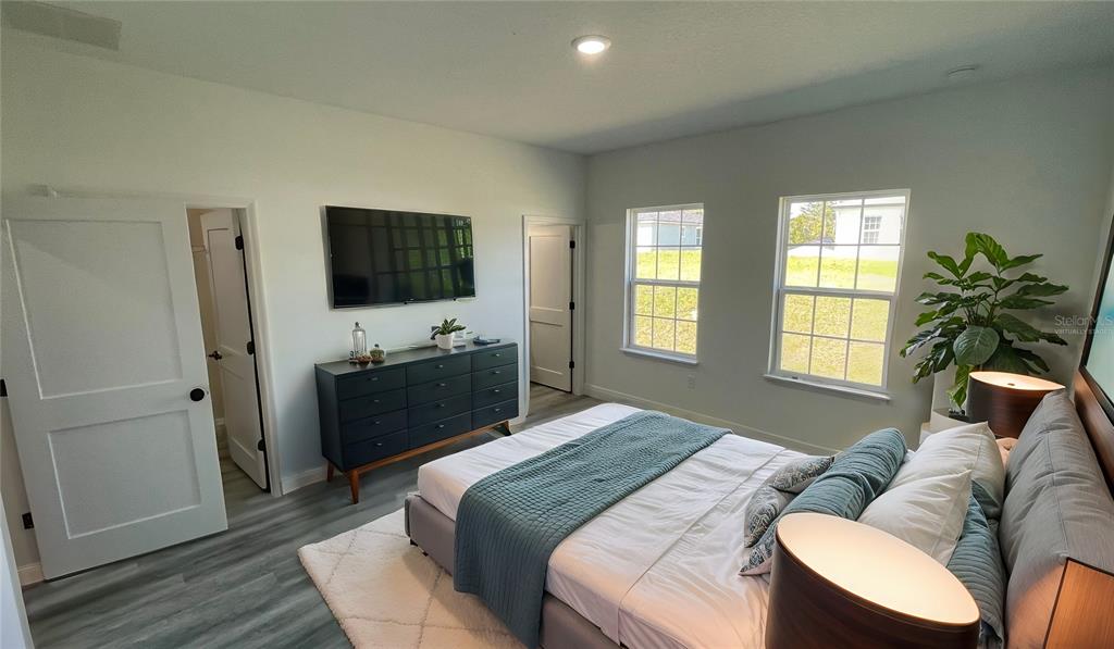 15282 Southwest 65th Avenue Road Ocala, FL 34473 - Photo 17 of 33 a bedroom with a bed and a flat screen tv