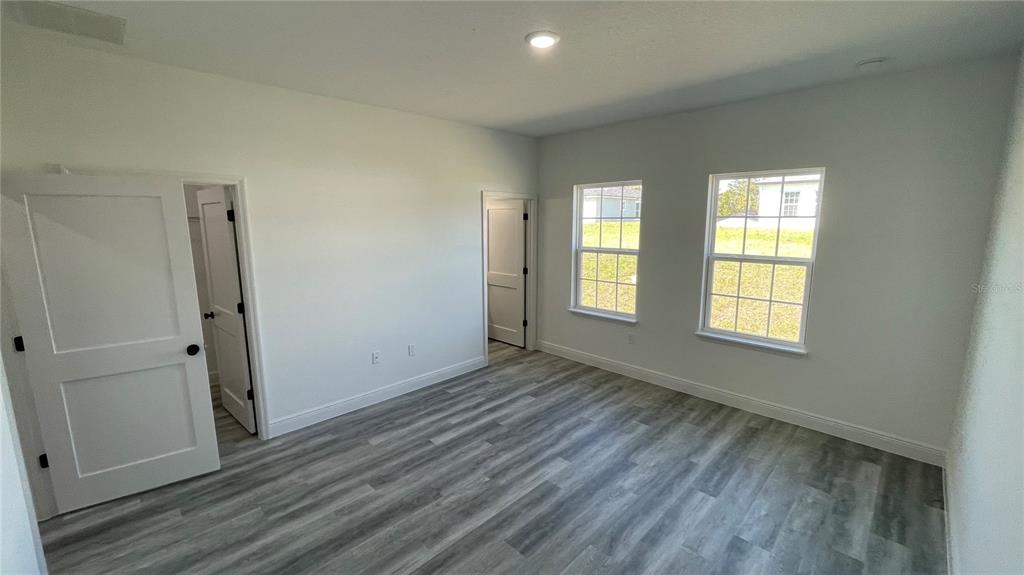 15282 Southwest 65th Avenue Road Ocala, FL 34473 - Photo 18 of 33 an empty room with wooden floor and windows