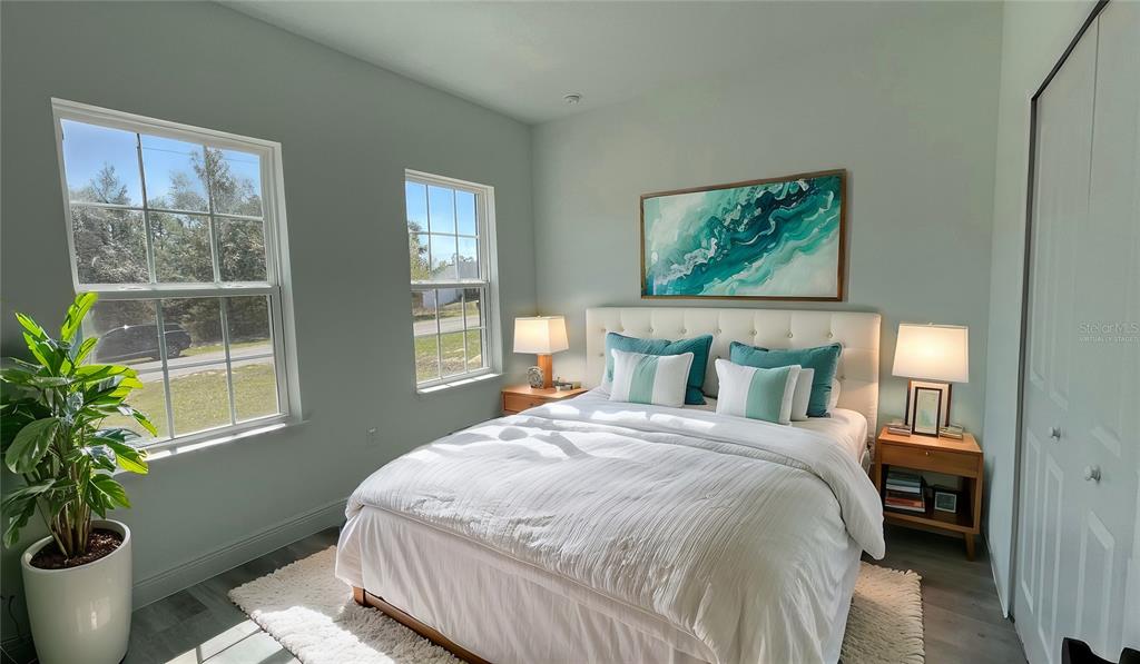 15282 Southwest 65th Avenue Road Ocala, FL 34473 - Photo 25 of 33 a bedroom with a large bed and a potted plant