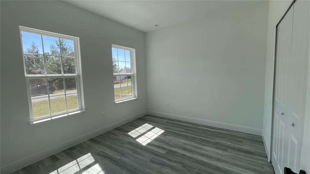 15282 Southwest 65th Avenue Road Ocala, FL 34473 - Photo 26 of 33 a view of empty room with wooden floor and fan
