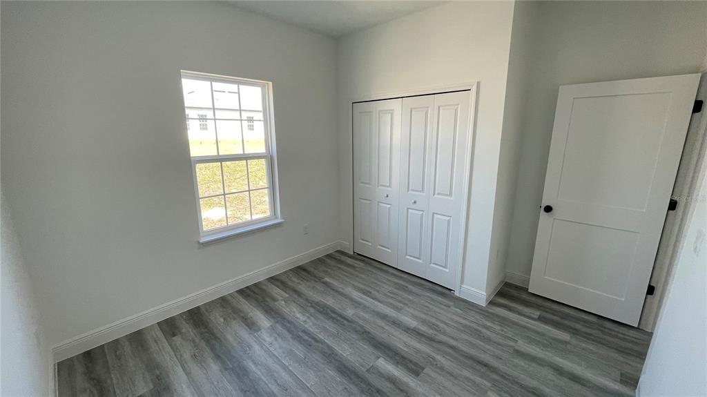 15282 Southwest 65th Avenue Road Ocala, FL 34473 - Photo 28 of 33 an empty room with wooden floor and windows