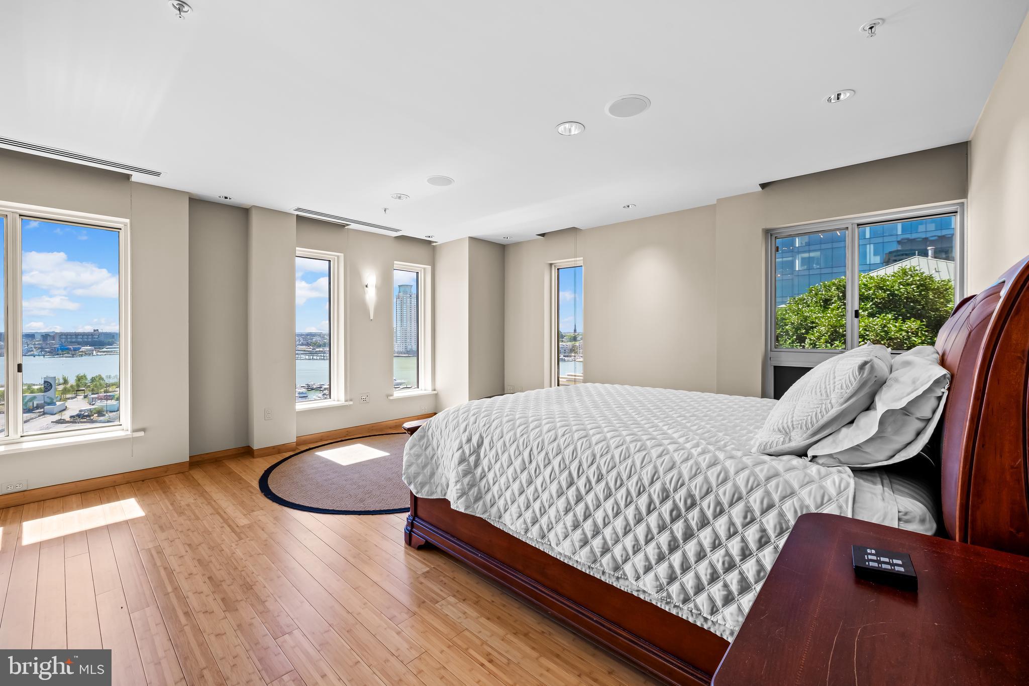 717 President Street, Unit PH802 Baltimore, MD 21202 - Photo 37 of 77 a spacious bedroom with a bed and wooden floor