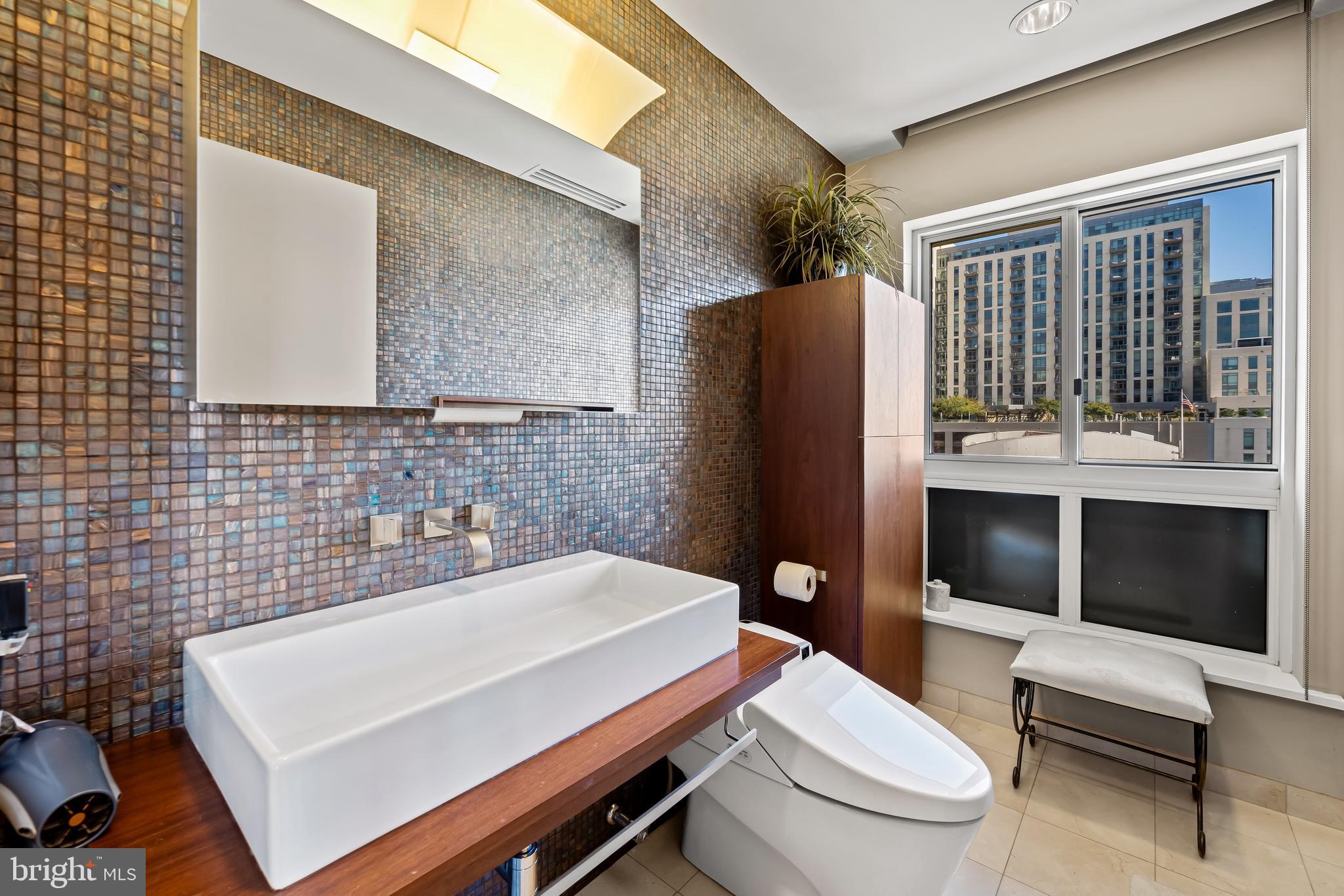 717 President Street, Unit PH802 Baltimore, MD 21202 - Photo 41 of 77 a bathroom with a toilet a sink and mirror