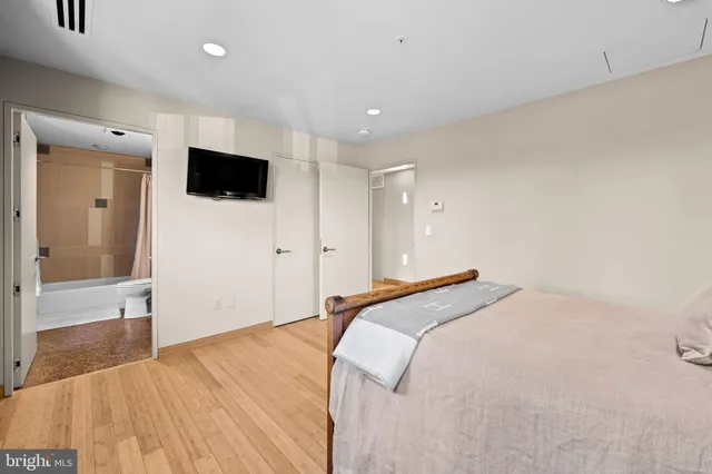 a living room with couches a flat screen tv and kitchen view
